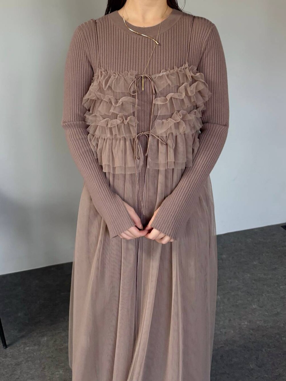 ホワイト系のブーツ、ブラウン系のワンピース、ホワイト系のハンドバッグを着用したレディースの冬コーディネートの3枚目の写真