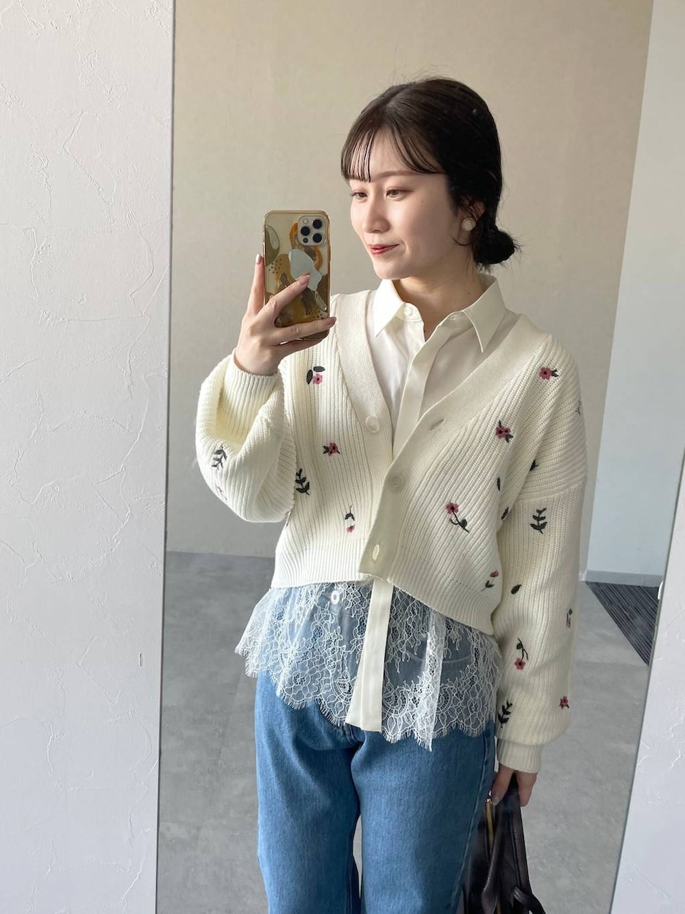 ブラウン系のボストンバッグ、ブラック系のローファー、ブルー系のデニムパンツを着用したレディースの冬コーディネートの3枚目の写真