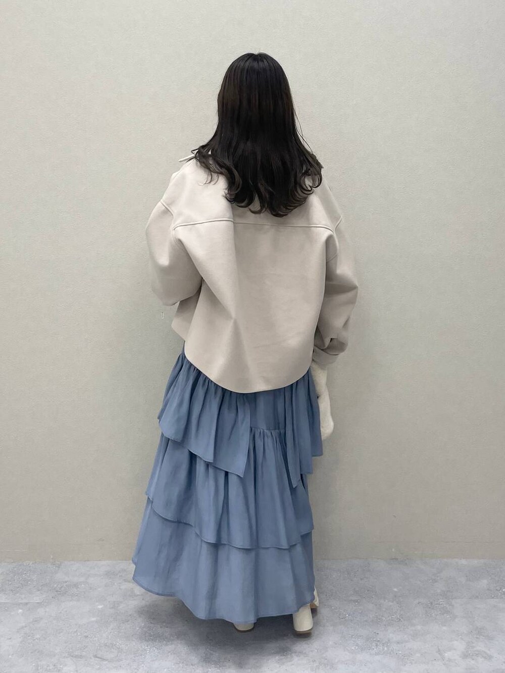 ホワイト系のその他アウター、ホワイト系のブーツ、ブルー系のスカートを着用したレディースの秋コーディネートの2枚目の写真