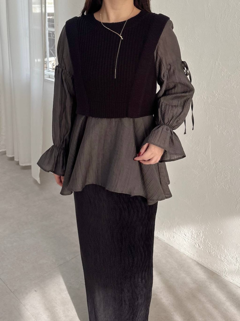 ホワイト系のブーツ、ブラック系のスカート、ブラック系のシャツ/ブラウスを着用したレディースの冬コーディネートの3枚目の写真