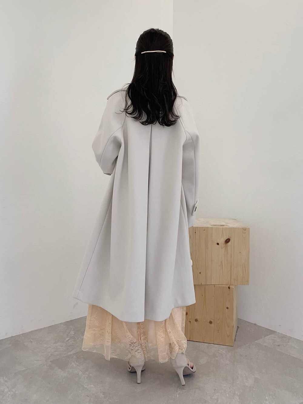 グレー系のパンプス、ホワイト系のボストンバッグ、ホワイト系のチェスターコートを着用したレディースの秋コーディネートの2枚目の写真