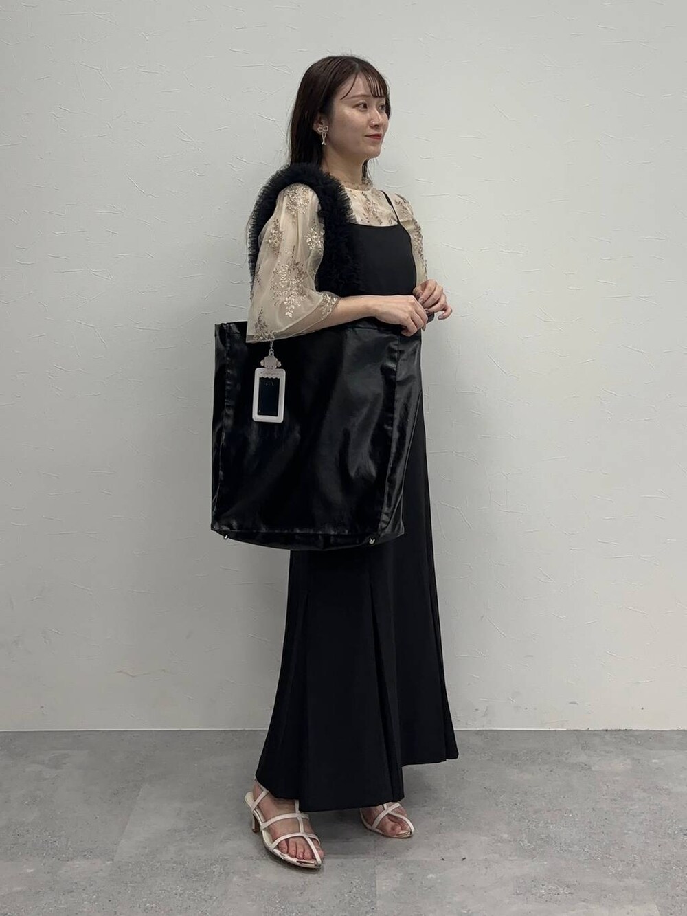 ホワイト系のシャツ/ブラウス、ホワイト系のサンダル、ブラック系のワンピースを着用したレディースの夏コーディネートの2枚目の写真