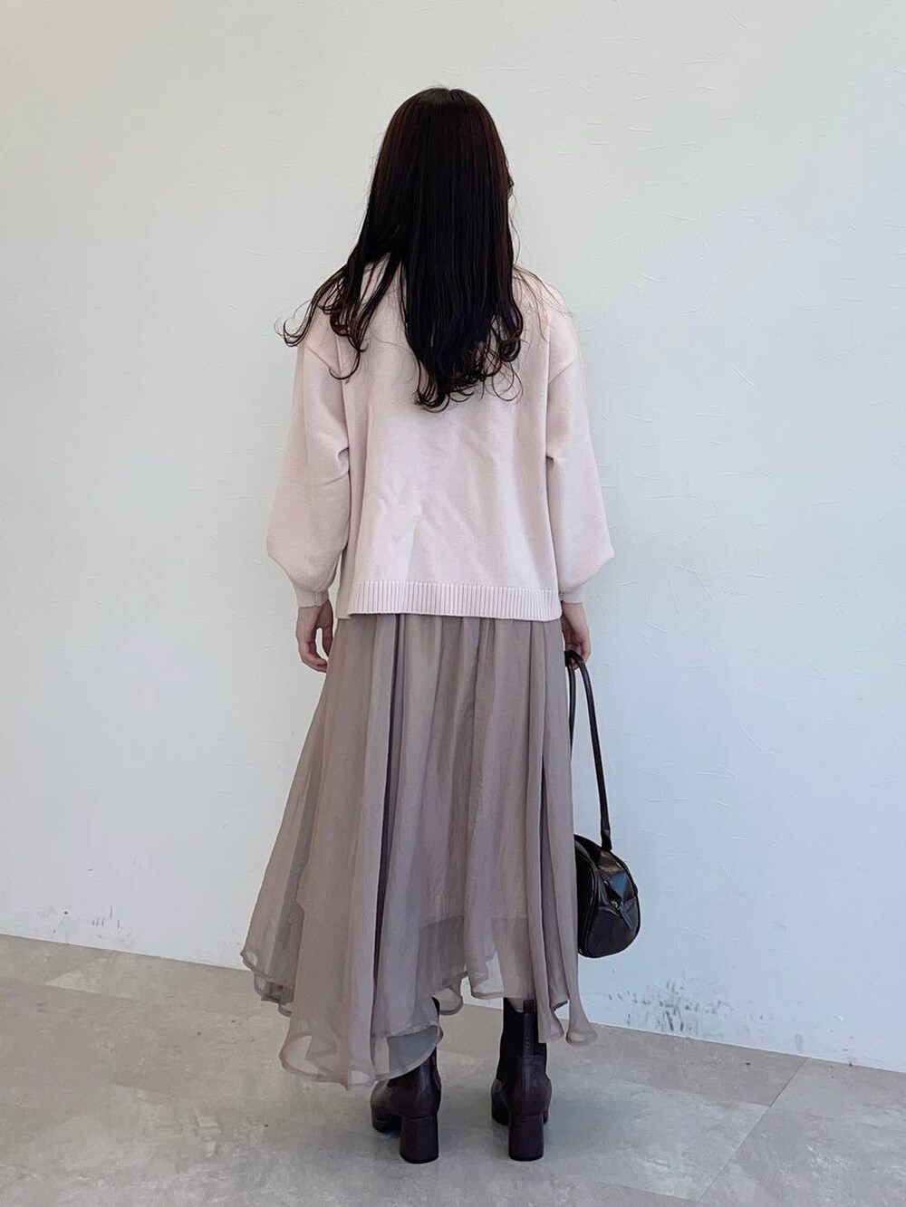 ブラウン系のブーツ、ホワイト系のブルゾン、ブラウン系のハンドバッグを着用したレディースの秋コーディネートの4枚目の写真