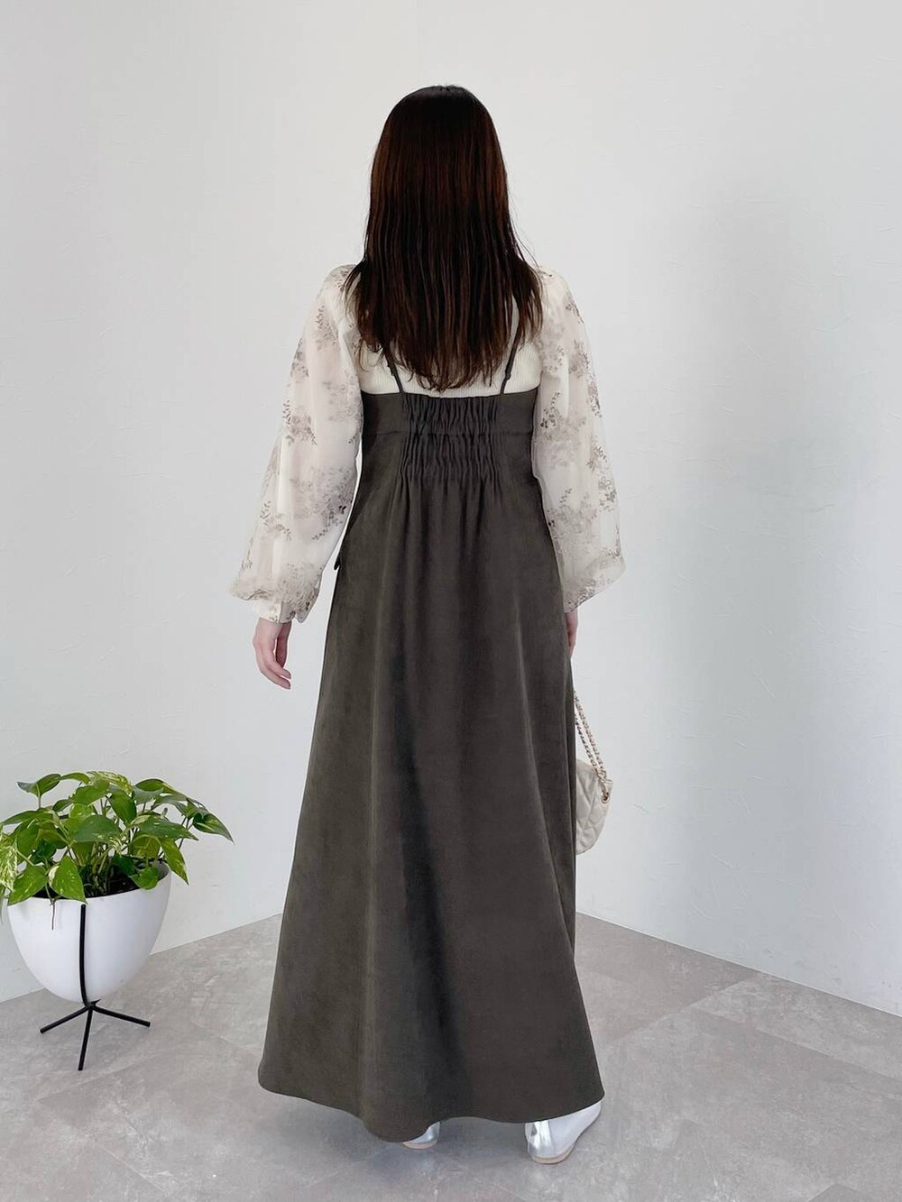 グレー系のワンピース、ホワイト系のショルダーバッグ、ホワイト系のニット/セーターを着用したレディースの冬コーディネートの3枚目の写真