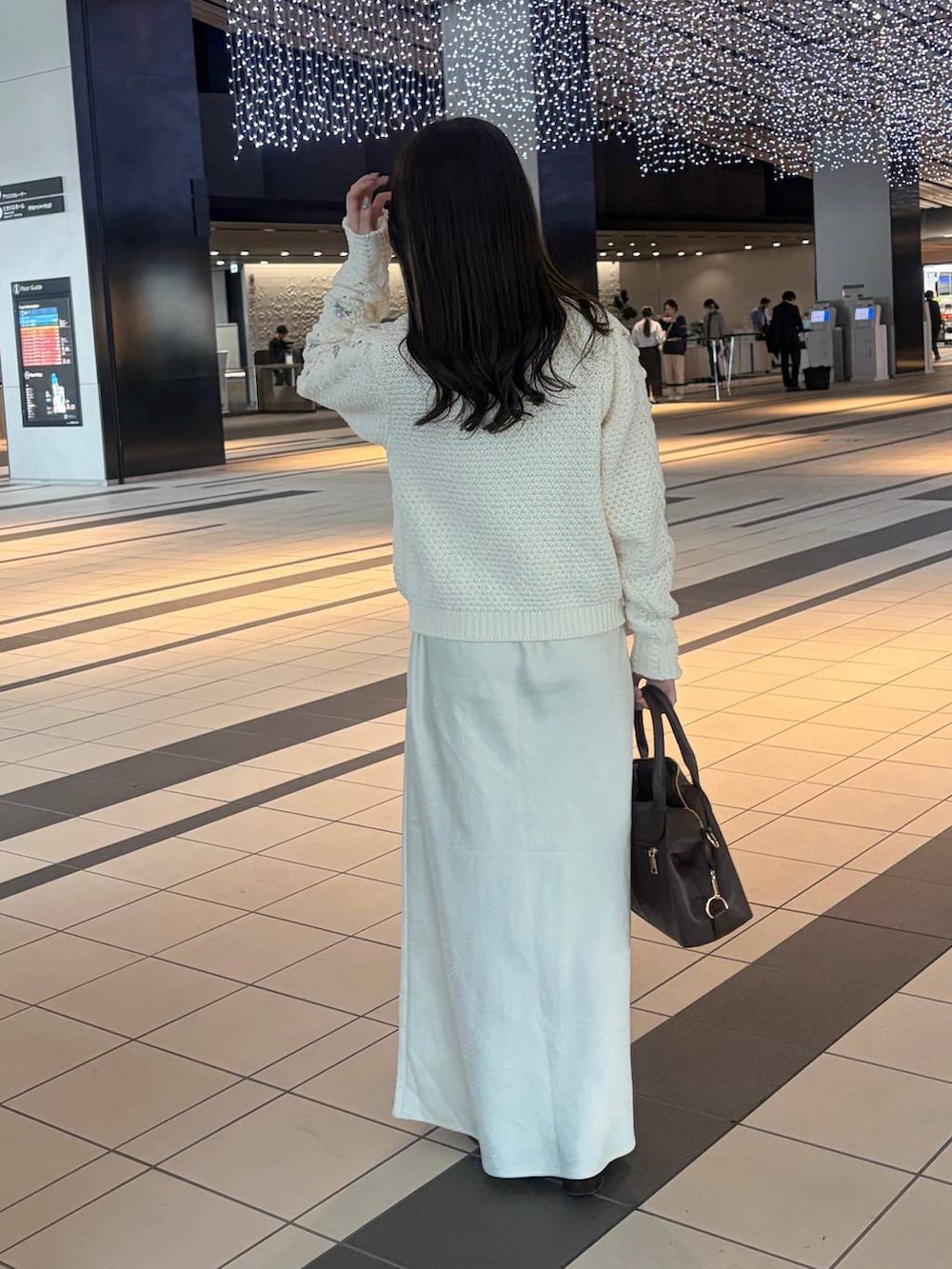 ホワイト系のスカート、ブラウン系のボストンバッグ、ホワイト系のニット/セーターを着用したレディースの冬コーディネートの3枚目の写真