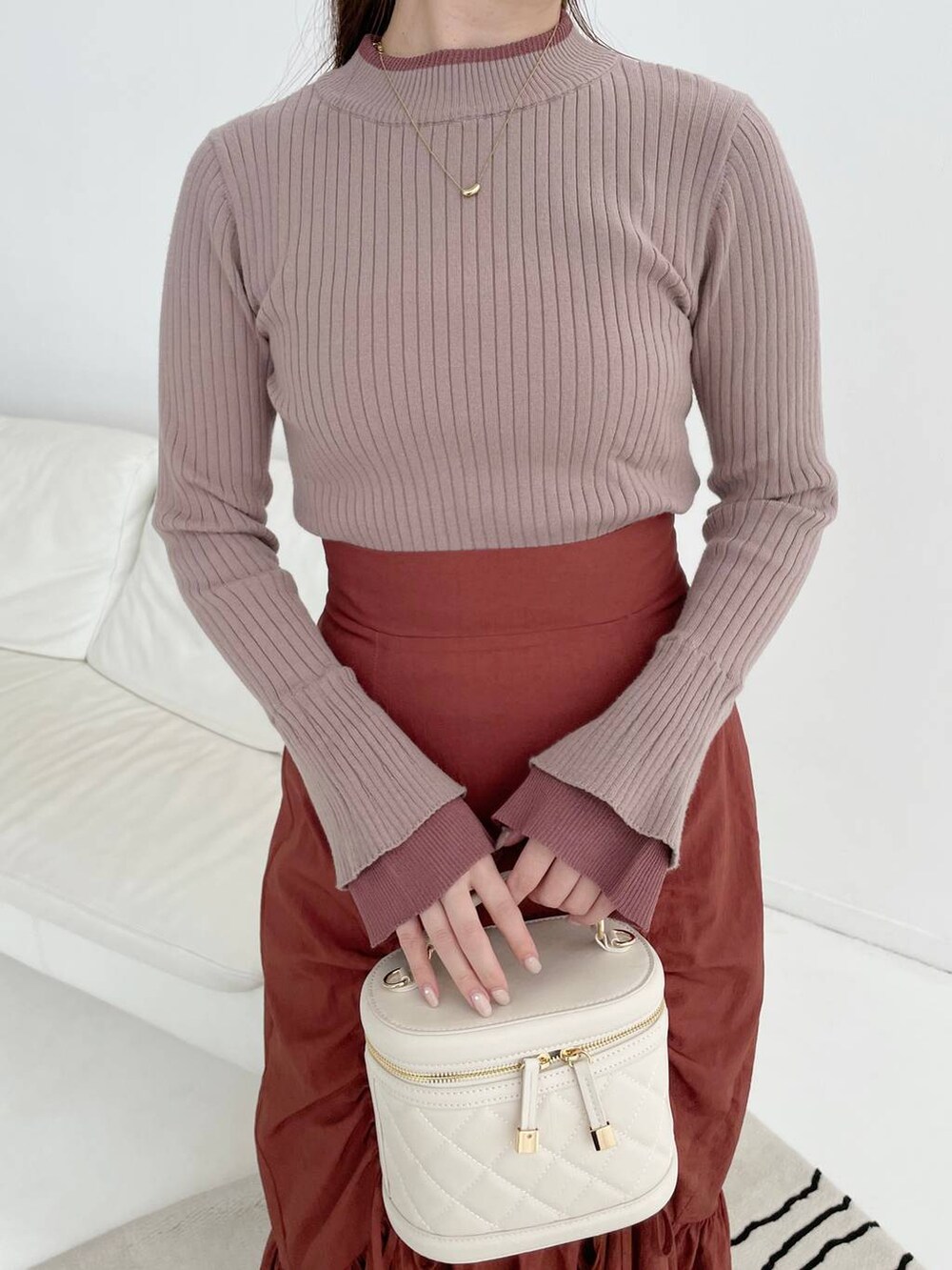 ホワイト系のブーツ、ブラウン系のニット/セーター、ホワイト系のショルダーバッグを着用したレディースの秋コーディネートの3枚目の写真
