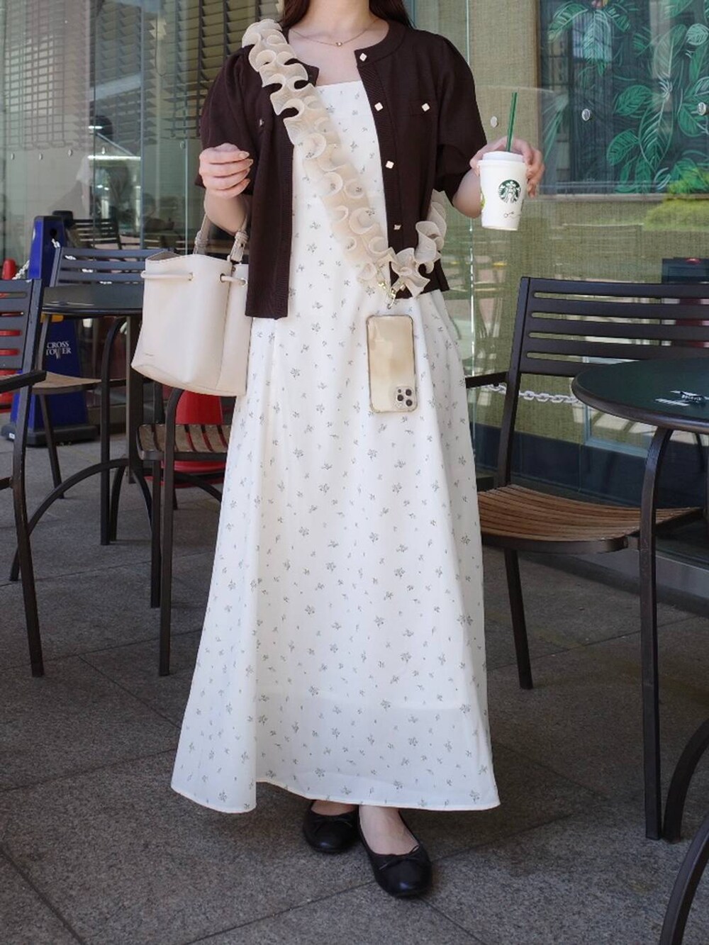 ブラウン系のカーディガン/ボレロ、ホワイト系のワンピース、ホワイト系のスマホグッズを着用したレディースの夏コーディネートの3枚目の写真