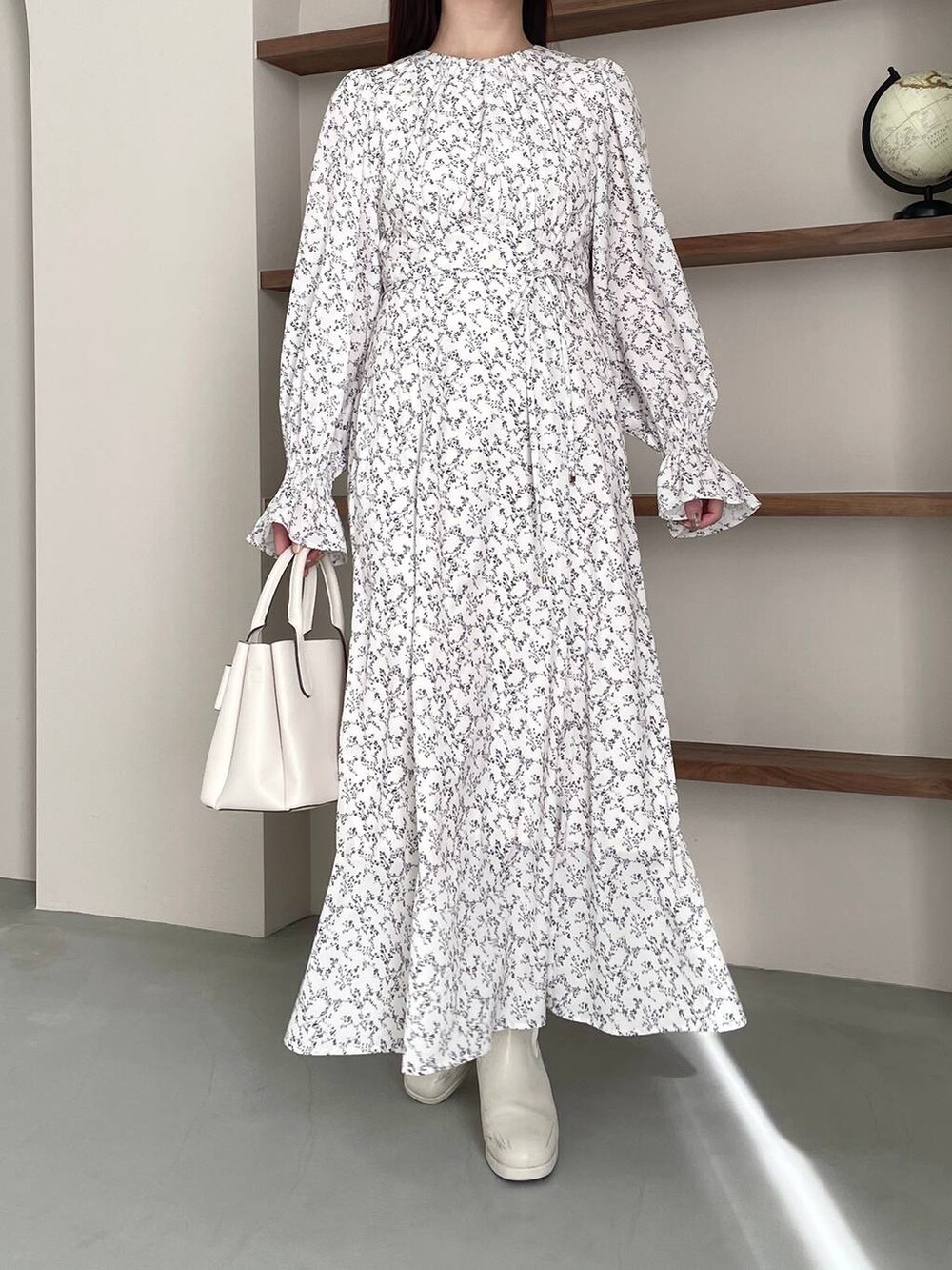 ホワイト系のブーツ、ホワイト系のショルダーバッグ、ホワイト系のワンピースを着用したレディースの冬コーディネートの6枚目の写真