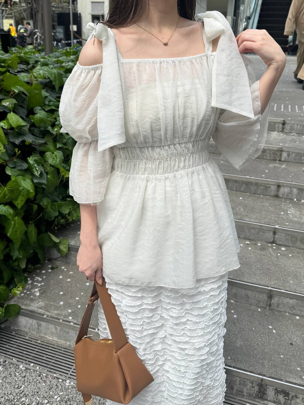 ベージュ系のサンダル、ホワイト系のスカート、ブラウン系のショルダーバッグを着用したレディースの春コーディネートの4枚目の写真