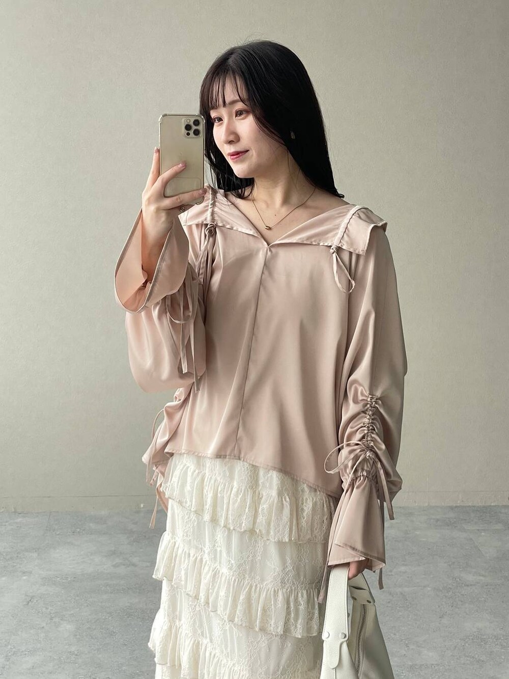 シルバー系のバレエシューズ、ホワイト系のスカート、ホワイト系のショルダーバッグを着用したレディースの春コーディネートの3枚目の写真