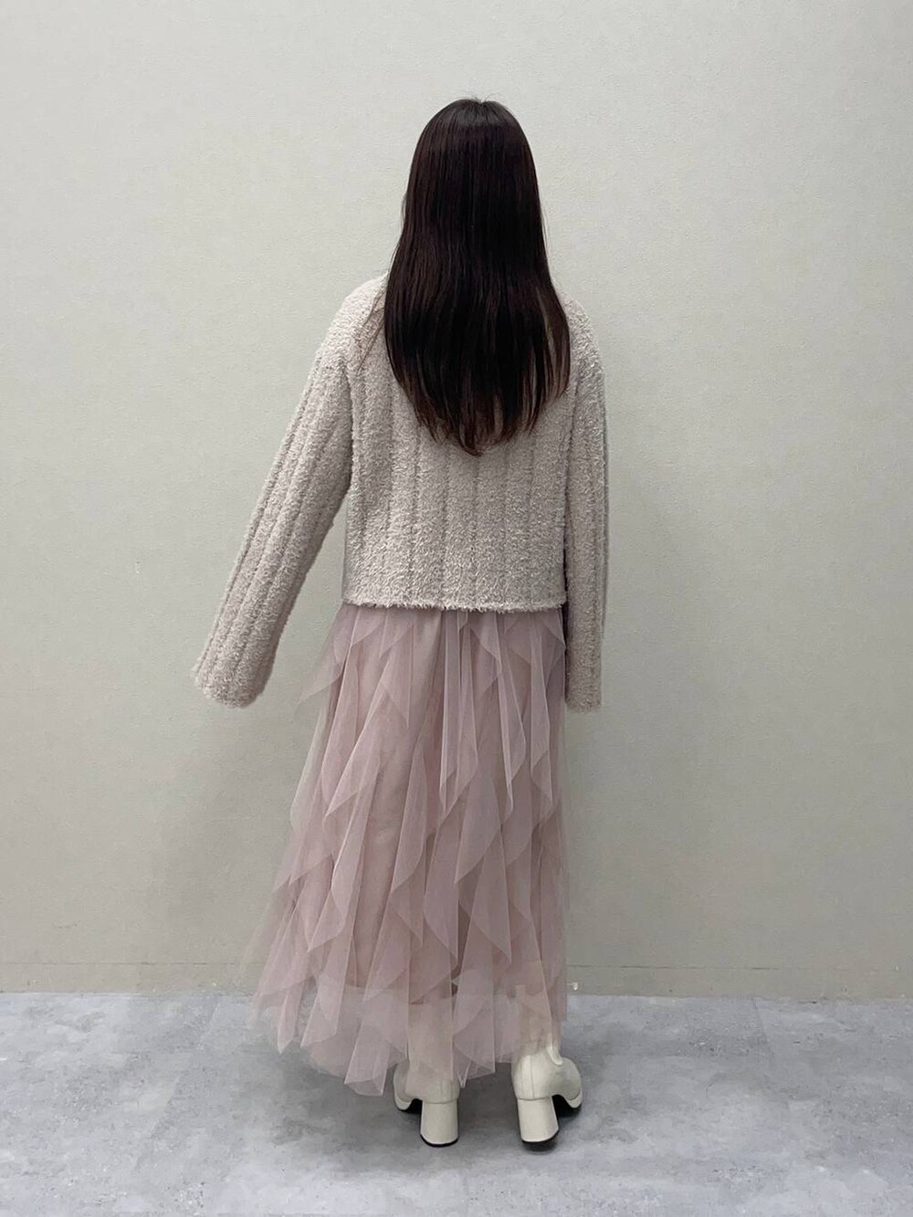 ホワイト系のブーツ、ホワイト系のブルゾン、ピンク系のスカートを着用したレディースの冬コーディネートの4枚目の写真