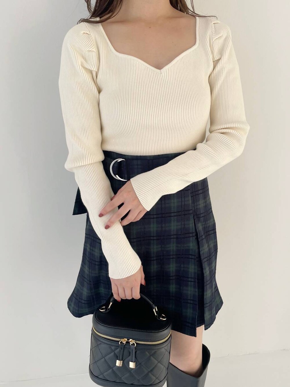 ブラック系のブーツ、ブラック系のショルダーバッグ、ホワイト系のニット/セーターを着用したレディースの秋コーディネートの3枚目の写真