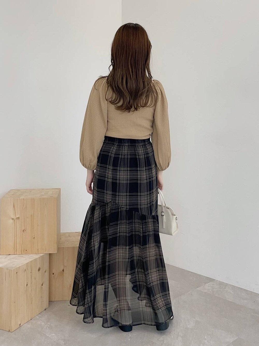 ホワイト系のボストンバッグ、ホワイト系のその他シューズ、ベージュ系のTシャツ/カットソーを着用したレディースの秋コーディネートの2枚目の写真