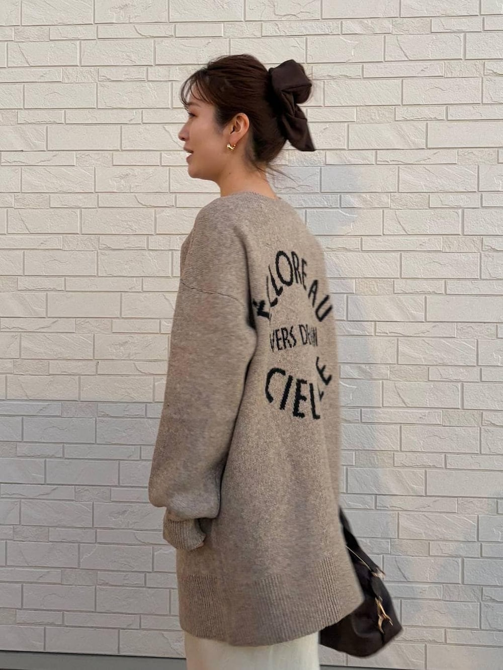 ホワイト系のスカート、ブラウン系のボストンバッグ、ベージュ系のカーディガン/ボレロを着用したレディースの冬コーディネートの5枚目の写真