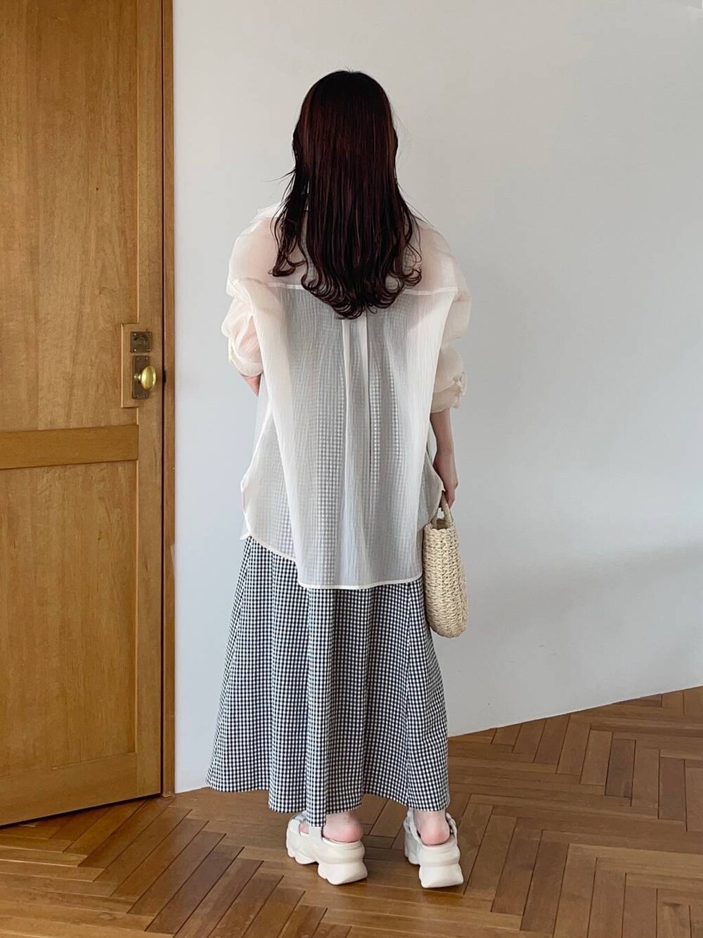 ベージュ系のシャツ/ブラウス、ホワイト系のサンダル、ベージュ系のかごバッグを着用したレディースの夏コーディネートの2枚目の写真