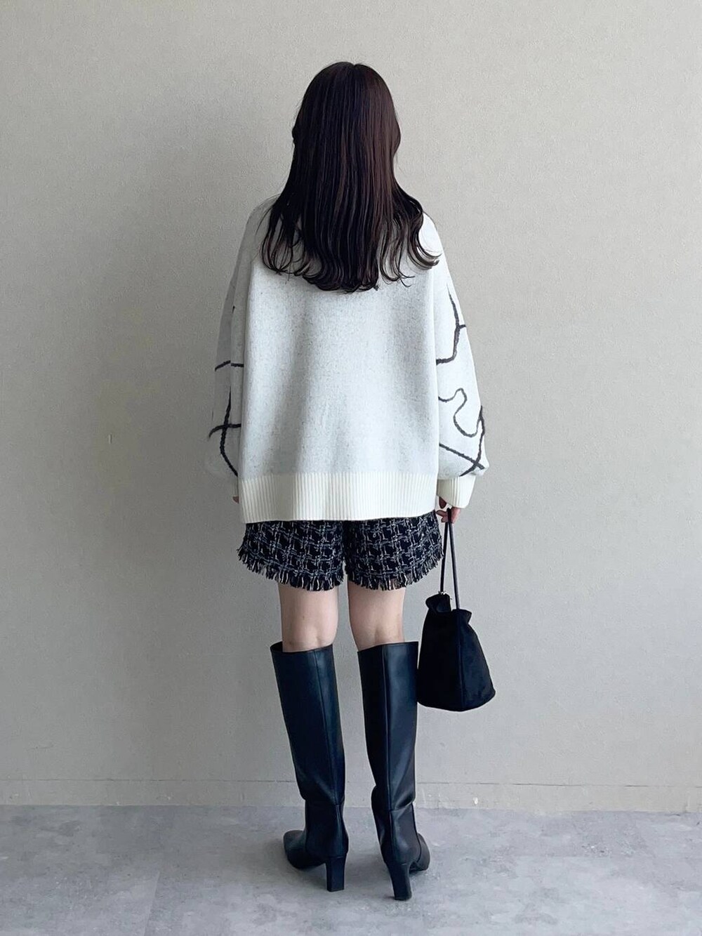 ホワイト系のニット/セーター、ブラック系のその他パンツ、ブラック系のハンドバッグを着用したレディースの秋コーディネートの2枚目の写真