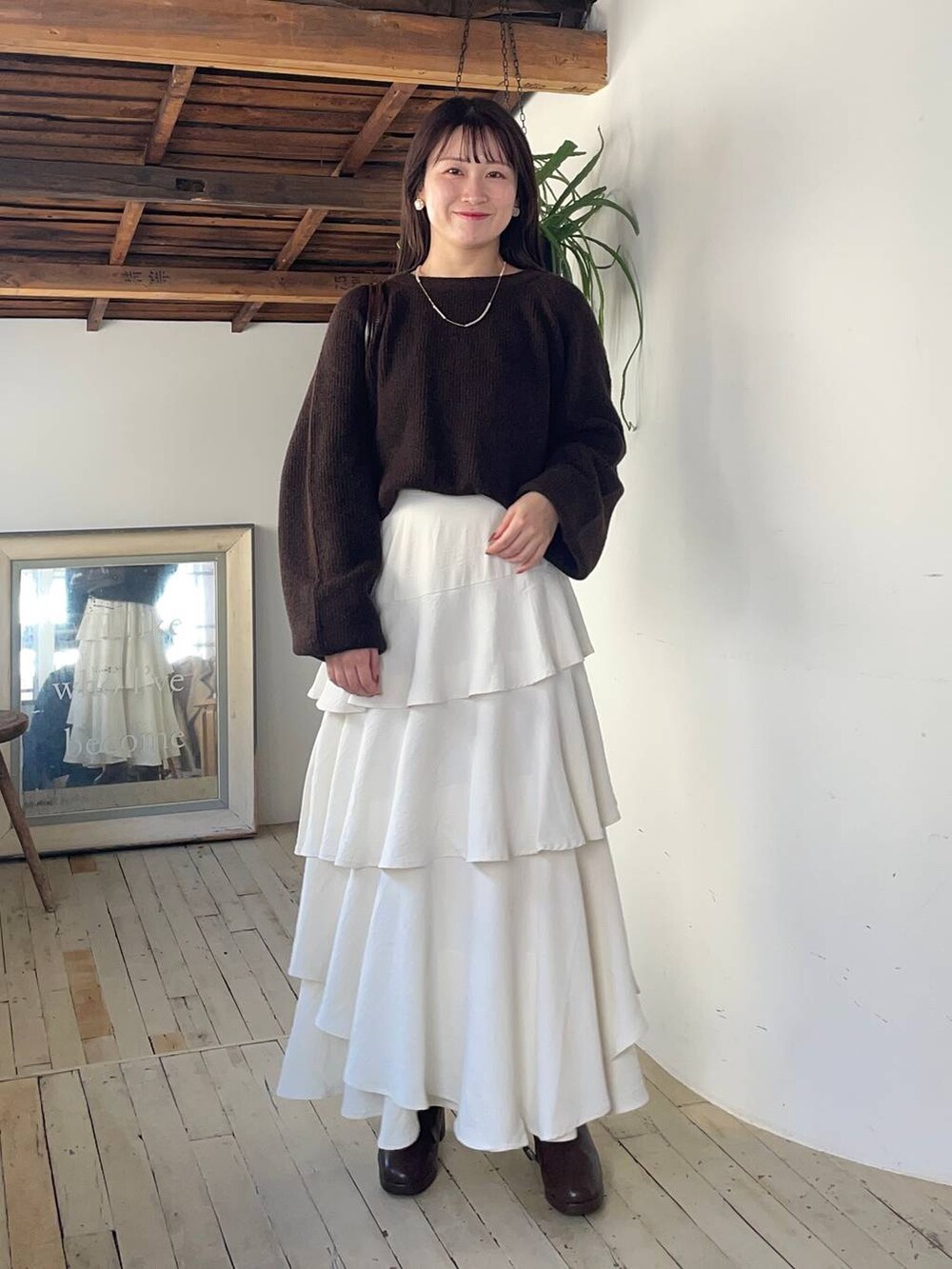 ベージュ系のピーコート、ブラウン系のブーツ、ブラウン系のニット/セーターを着用したレディースの冬コーディネートの3枚目の写真