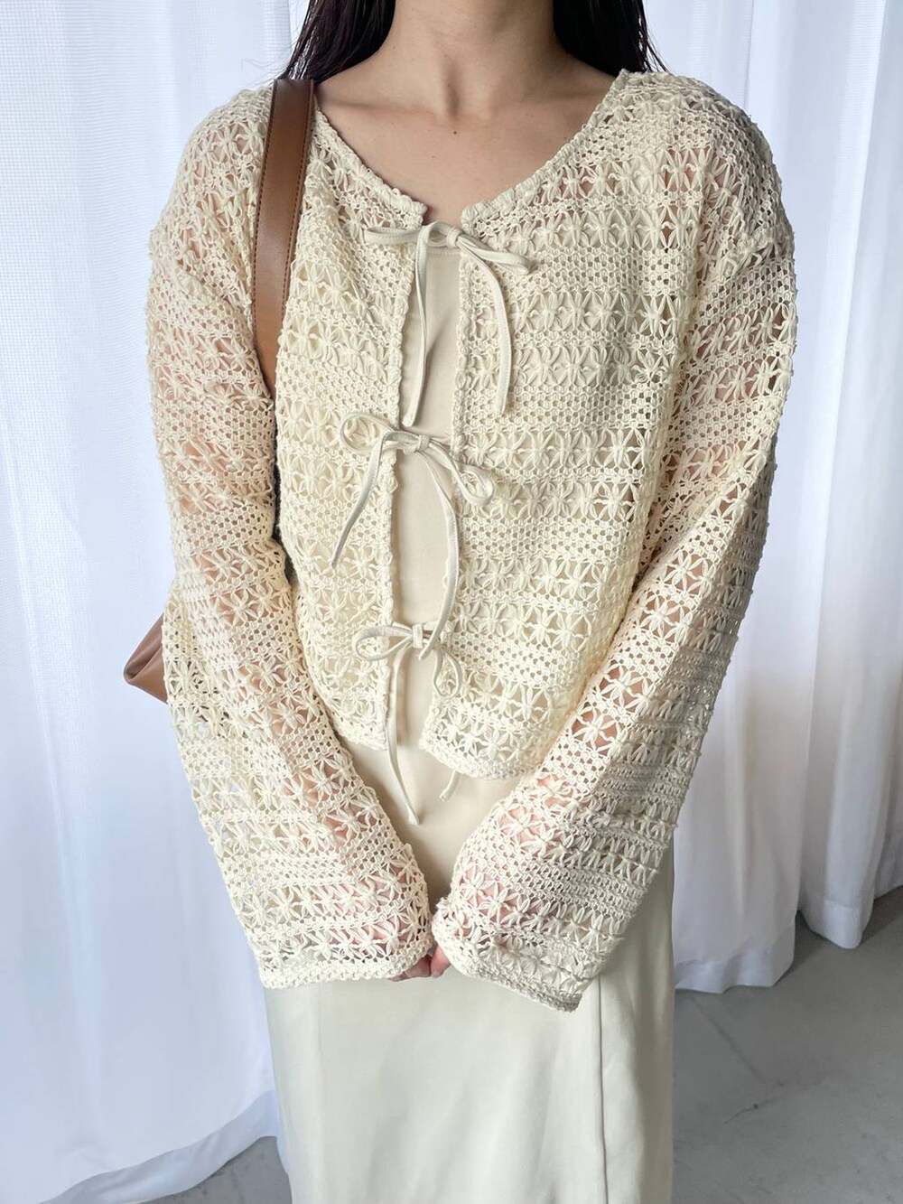 ホワイト系のドレス、ホワイト系のサンダル、ホワイト系のカーディガン/ボレロを着用したレディースの春コーディネートの3枚目の写真