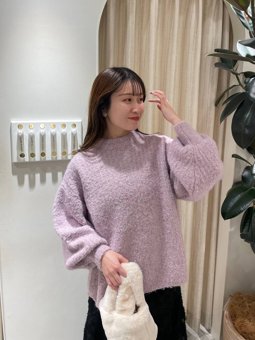 ホワイト系のブーツ、ピンク系のニット/セーター、ホワイト系のハンドバッグを着用したレディースの冬コーディネートの4枚目の写真