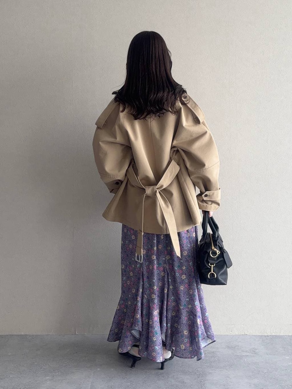 ブラック系のボストンバッグ、ブラック系のサンダル、ベージュ系のトレンチコートを着用したレディースの冬コーディネートの2枚目の写真