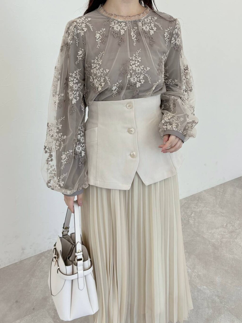 ホワイト系のショルダーバッグ、ブラウン系のシャツ/ブラウス、ブラウン系のブーツを着用したレディースの冬コーディネートの3枚目の写真