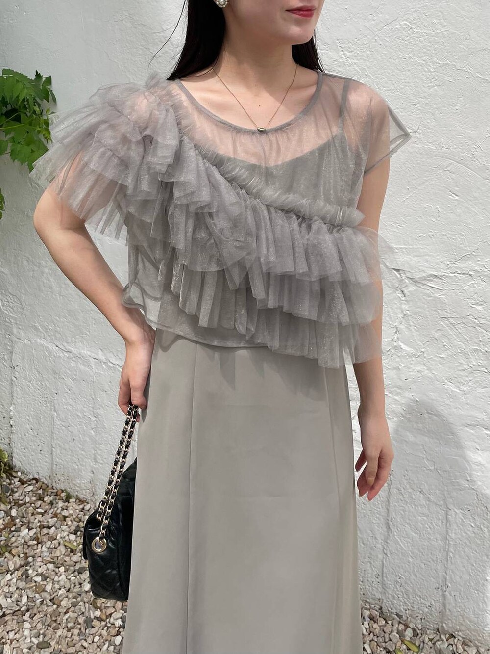 ブラック系のパンプス、グリーン系のドレス、ブラック系のショルダーバッグを着用したレディースの夏コーディネートの4枚目の写真