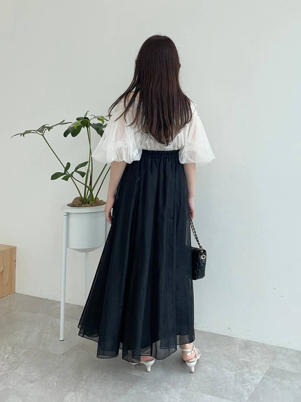 ホワイト系のシャツ/ブラウス、ブラック系のショルダーバッグ、ホワイト系のサンダルを着用したレディースの夏コーディネートの2枚目の写真