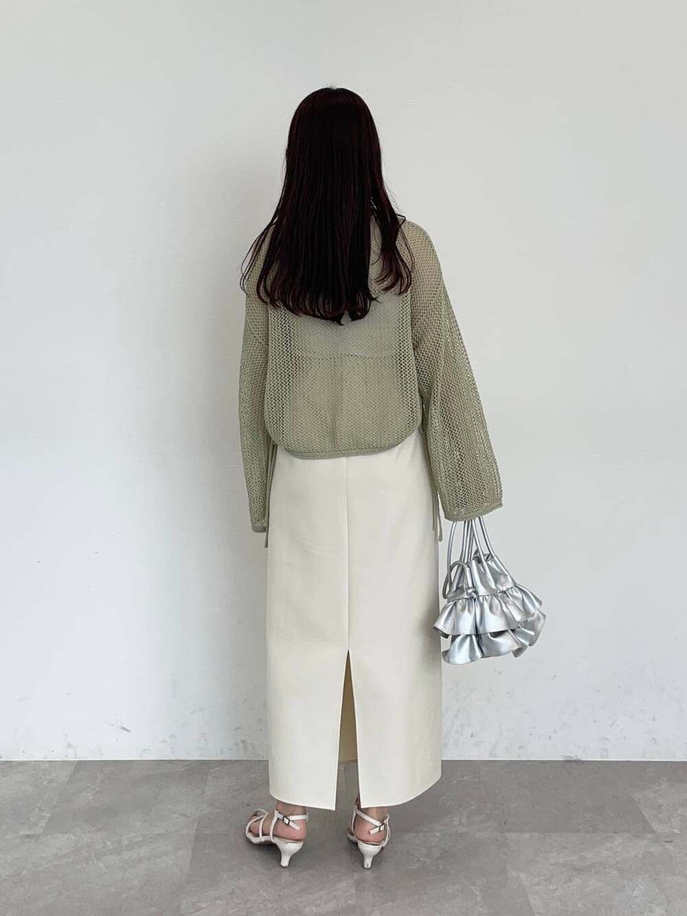 ホワイト系のスカート、シルバー系のショルダーバッグ、ホワイト系のサンダルを着用したレディースの夏コーディネートの2枚目の写真