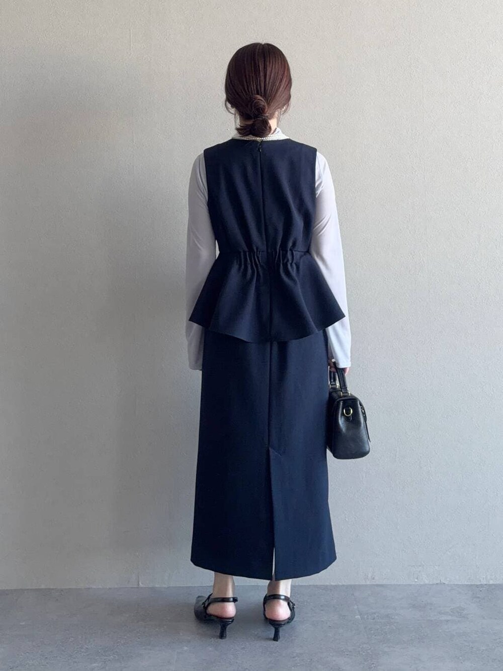 グレー系のTシャツ/カットソー、ブラック系のショルダーバッグ、ブルー系のテーラードジャケットを着用したレディースの冬コーディネートの4枚目の写真