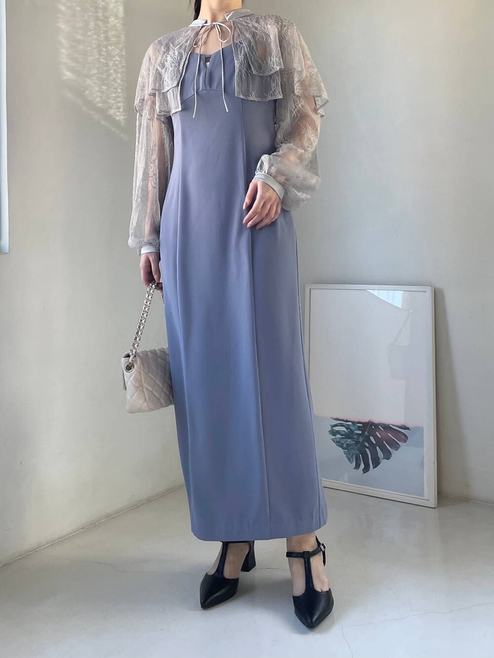 ブルー系のドレス、ホワイト系のショルダーバッグ、ブラック系のパンプスを着用したレディースの冬コーディネートの4枚目の写真