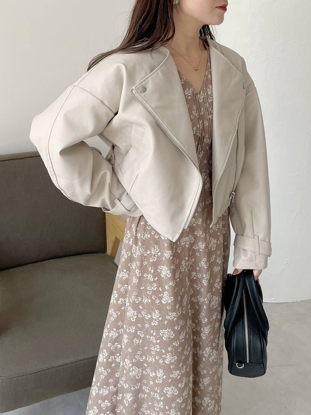 ブラック系のボストンバッグ、ブラック系のブーツ、ベージュ系のワンピースを着用したレディースの秋コーディネートの4枚目の写真