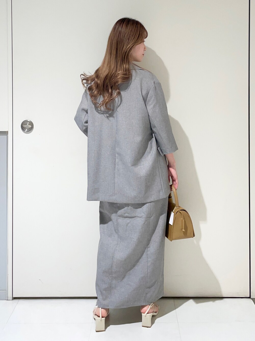 ホワイト系のシャツ/ブラウス、グレー系のテーラードジャケット、グレー系のスカートを着用したレディースの春コーディネートの2枚目の写真