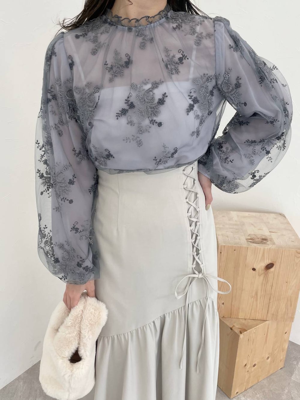 ホワイト系のチェスターコート、ホワイト系のブーツ、ブルー系のシャツ/ブラウスを着用したレディースの秋コーディネートの6枚目の写真