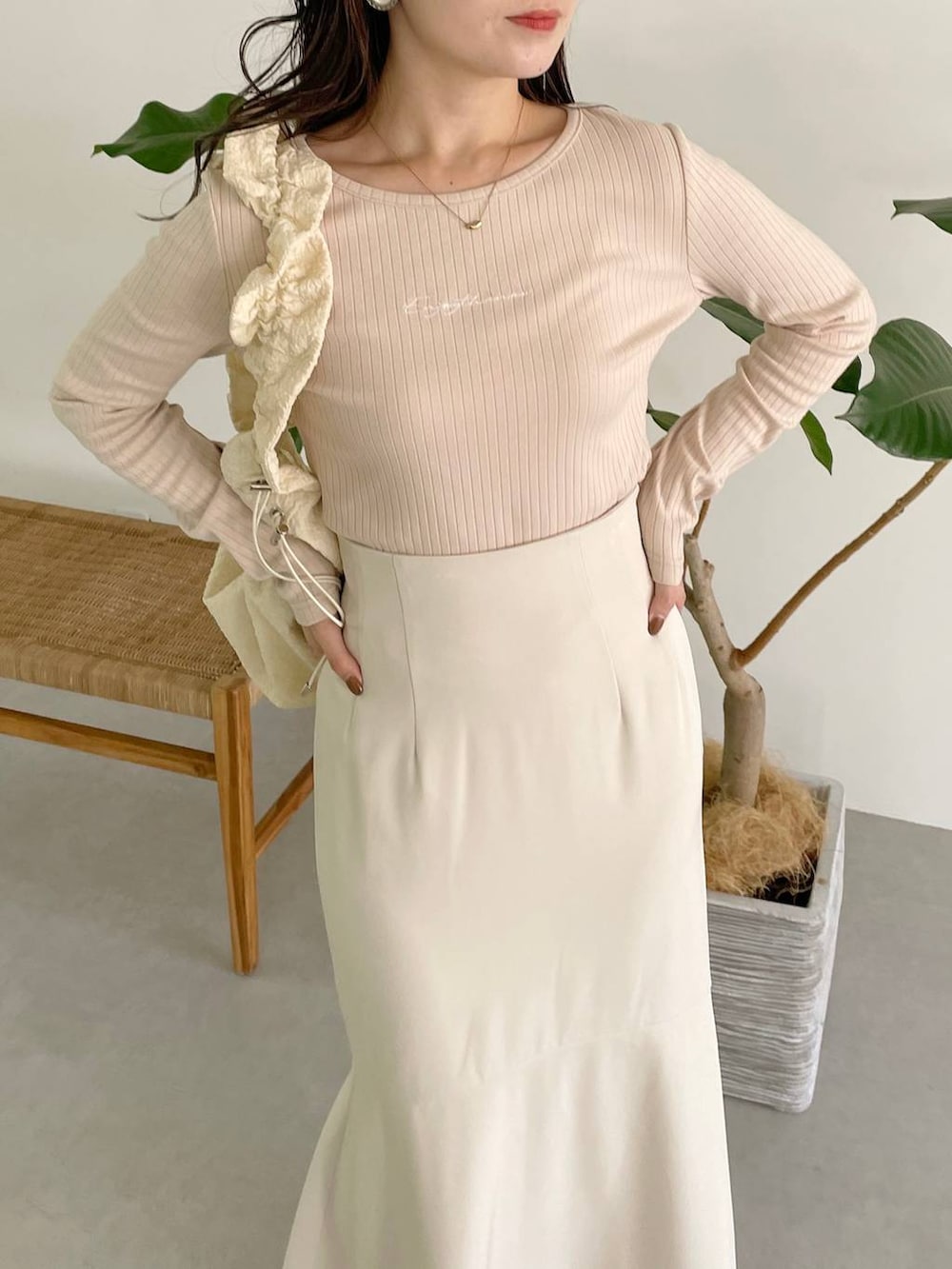 ホワイト系のハンドバッグ、ホワイト系のブーツ、ホワイト系のスカートを着用したレディースの秋コーディネートの7枚目の写真