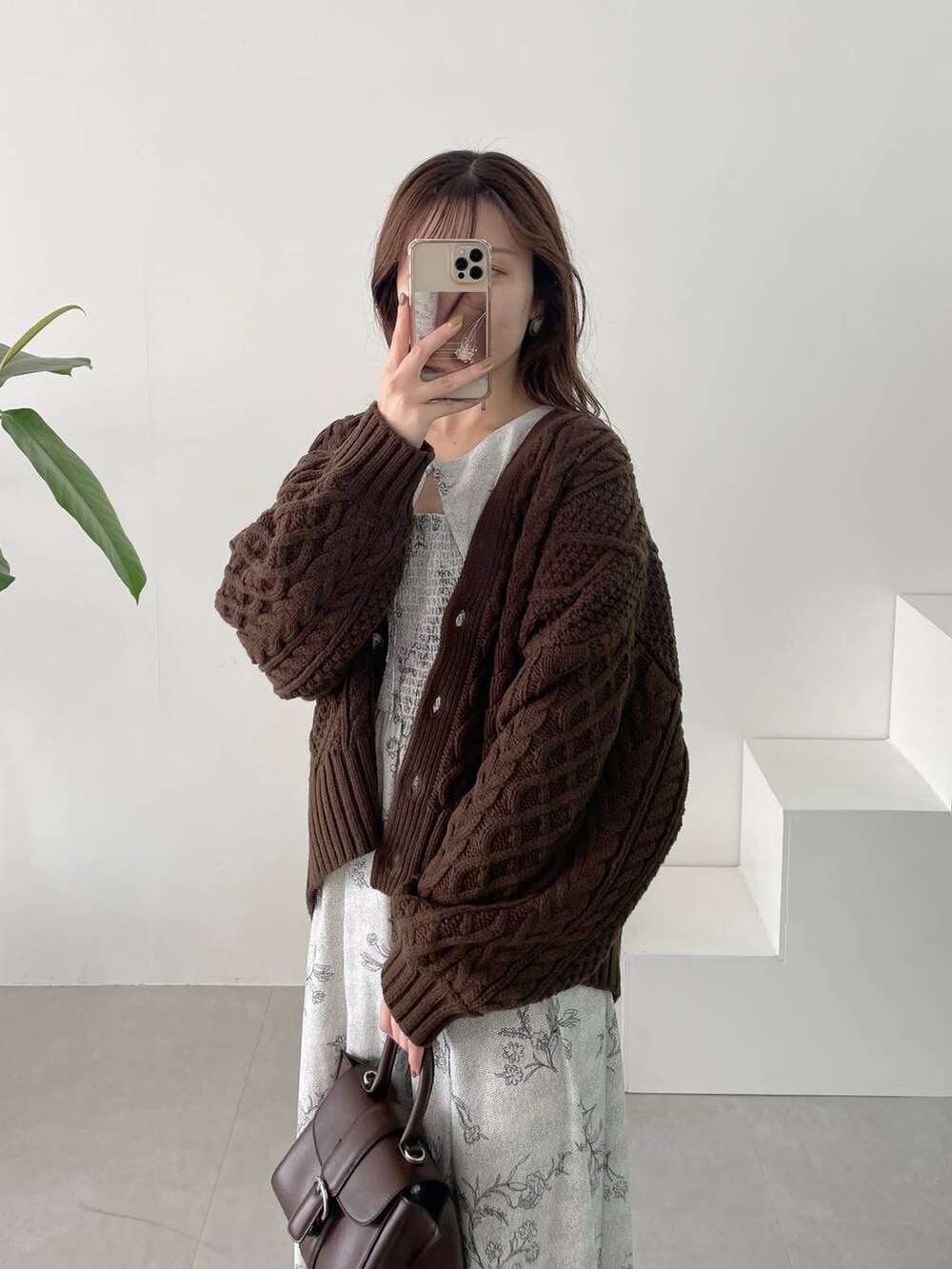 ブラウン系のハンドバッグ、ホワイト系のブーツ、ブラウン系のカーディガン/ボレロを着用したレディースの秋コーディネートの4枚目の写真