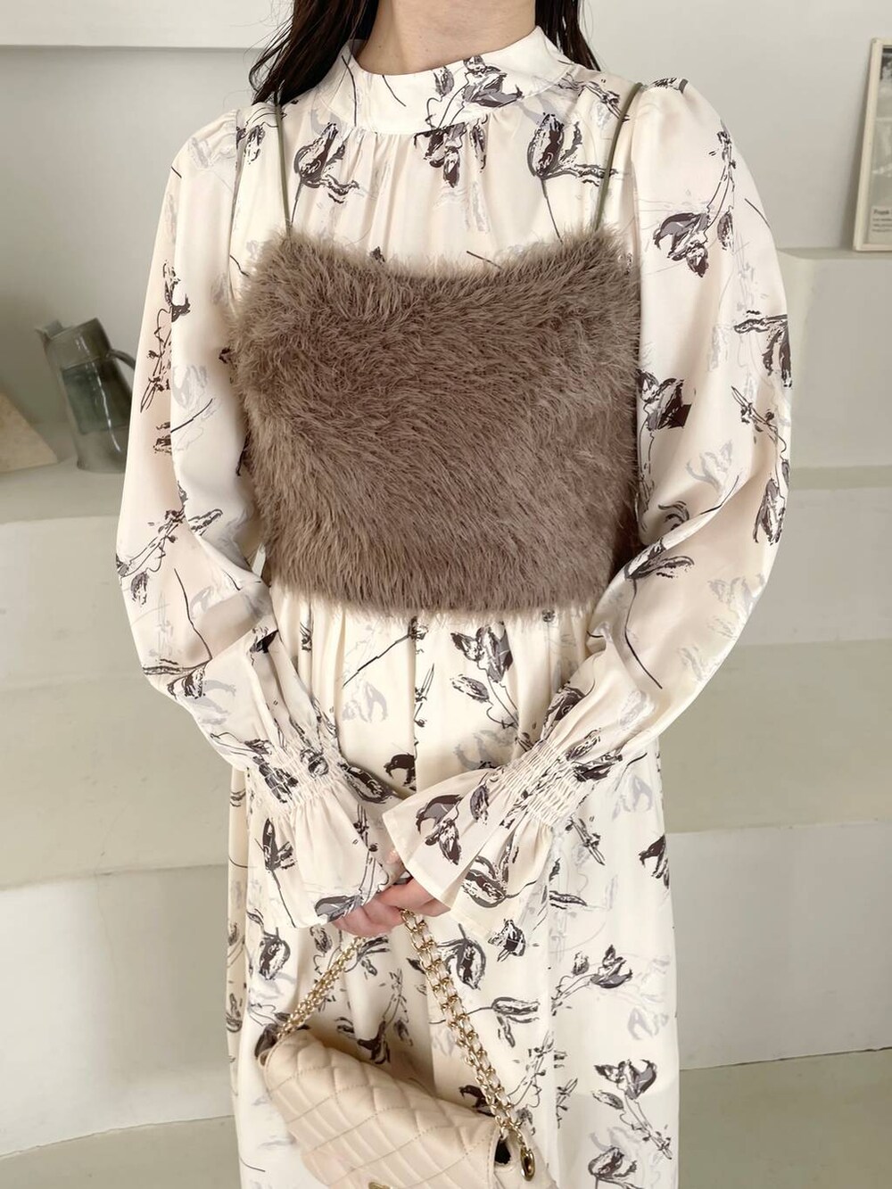 ホワイト系のショルダーバッグ、ホワイト系のワンピース、ホワイト系のパンプスを着用したレディースの冬コーディネートの3枚目の写真