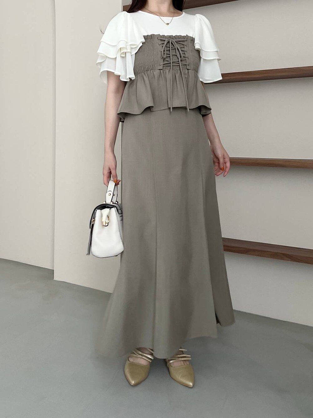 ゴールド系のパンプス、ホワイト系のショルダーバッグ、ホワイト系のTシャツ/カットソーを着用したレディースの春コーディネートの5枚目の写真