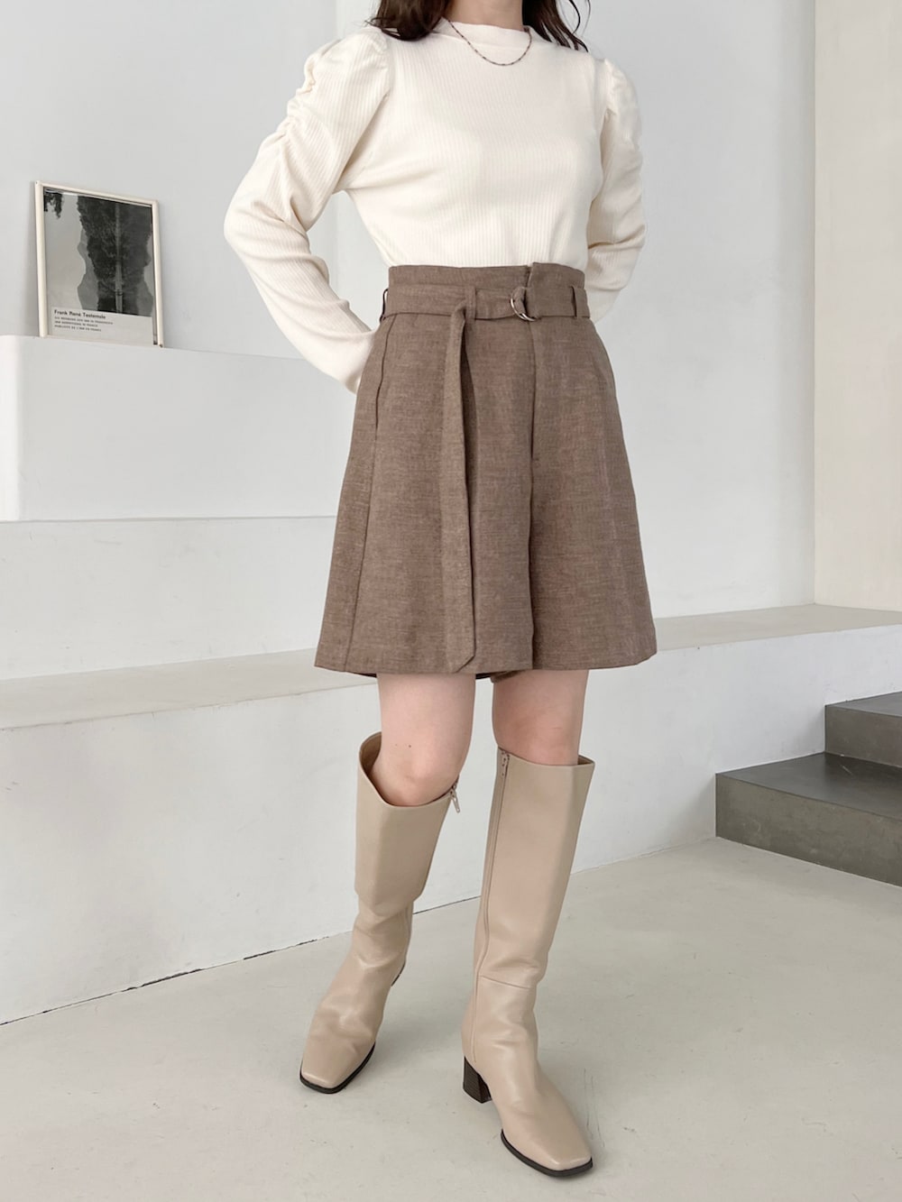 ホワイト系のニット/セーター、ベージュ系のチェスターコート、ベージュ系のその他パンツを着用したレディースの冬コーディネートの3枚目の写真