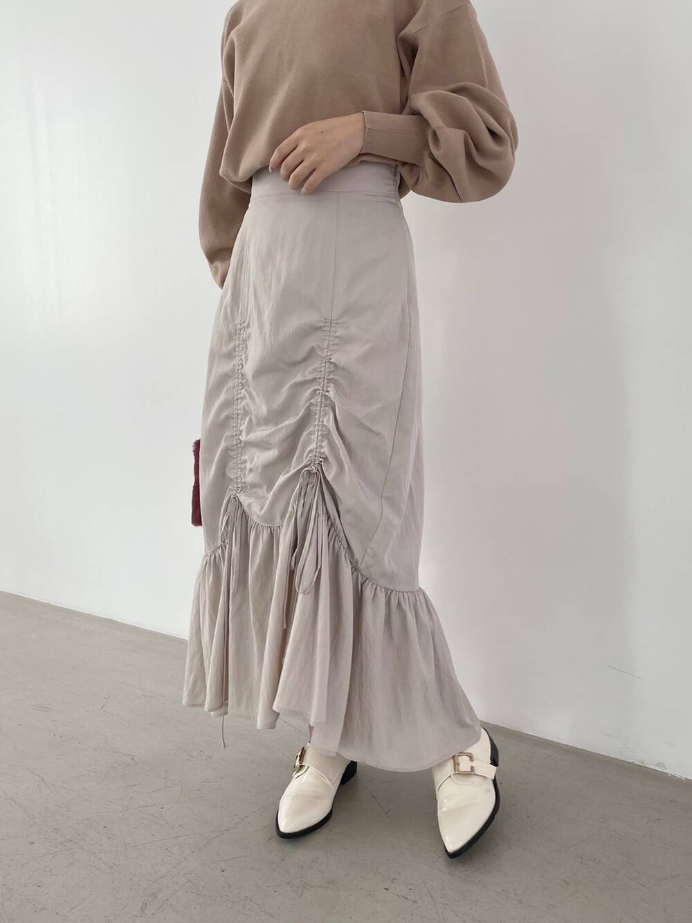 ホワイト系のその他シューズ、ブラウン系のニット/セーター、ピンク系のハンドバッグを着用したレディースの秋コーディネートの4枚目の写真