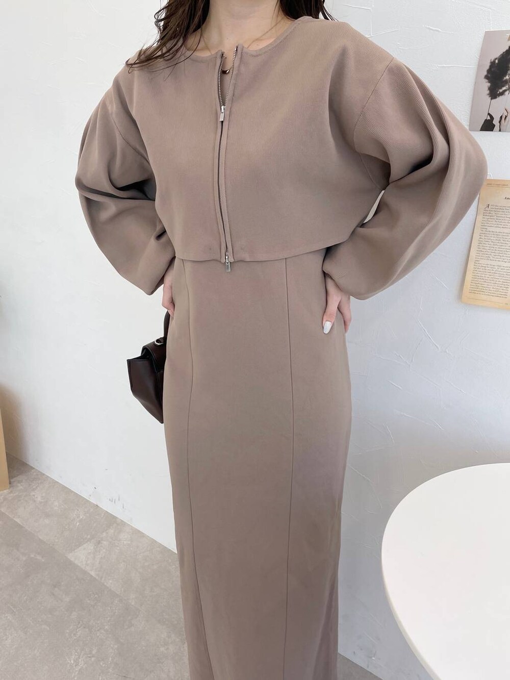 ブラウン系のハンドバッグ、ホワイト系のブーツ、ブラウン系のワンピースを着用したレディースの冬コーディネートの5枚目の写真