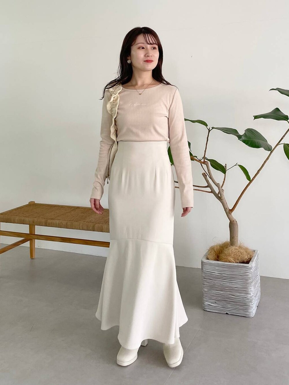 ホワイト系のハンドバッグ、ホワイト系のブーツ、ホワイト系のスカートを着用したレディースの秋コーディネートの5枚目の写真