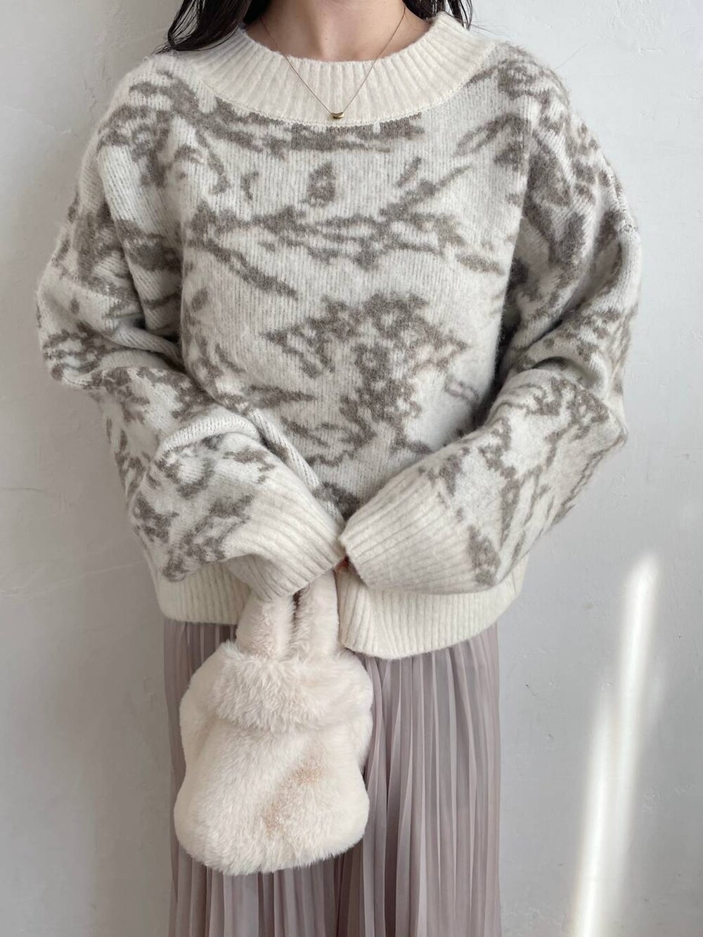 ホワイト系のブーツ、ホワイト系のハンドバッグ、ベージュ系のスカートを着用したレディースの冬コーディネートの3枚目の写真