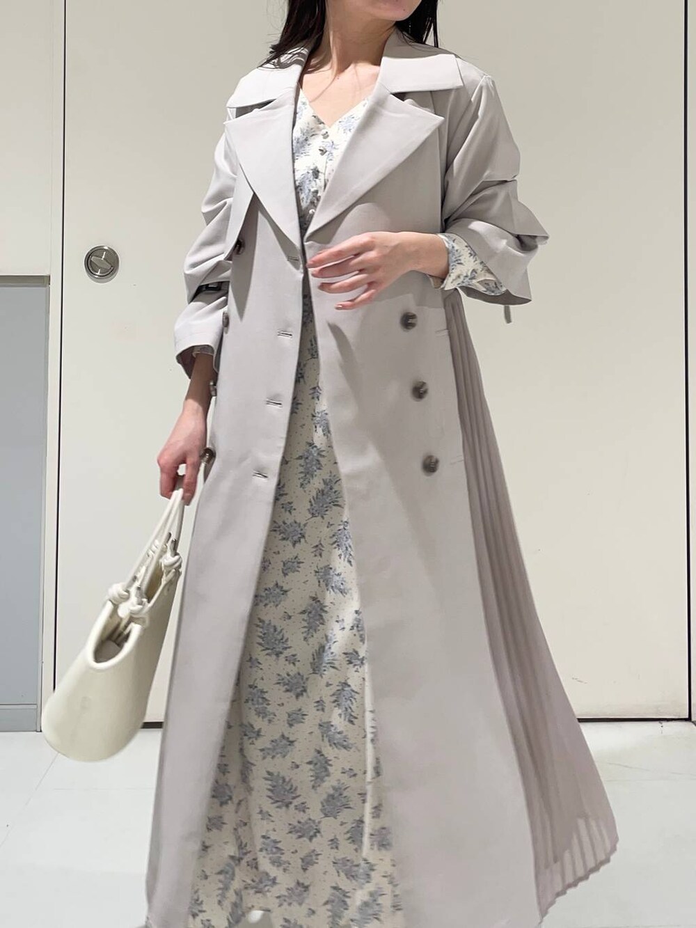 ブルー系のワンピース、ホワイト系のブーツ、グレー系のトレンチコートを着用したレディースの春コーディネートの3枚目の写真