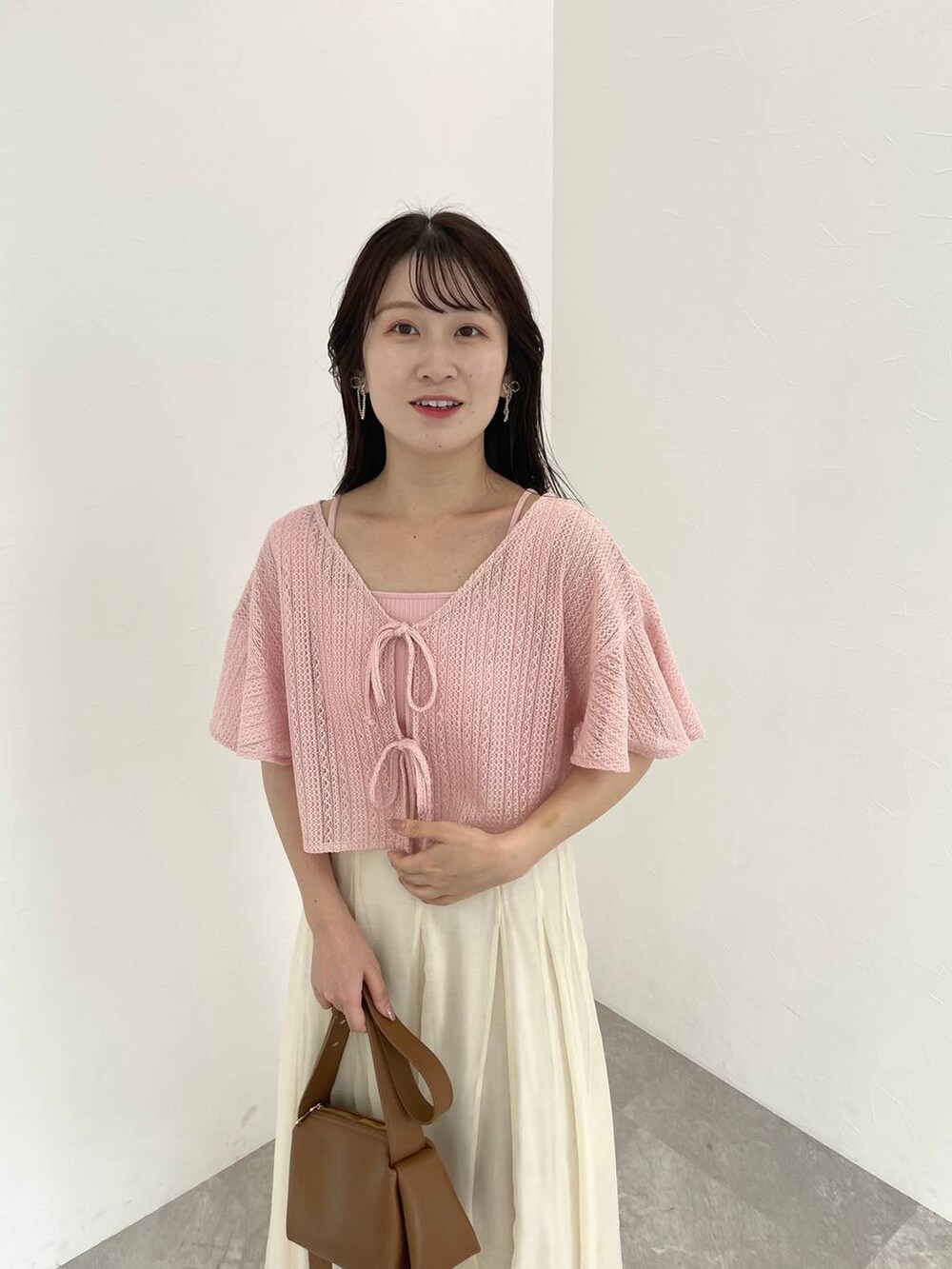 ブラウン系のショルダーバッグ、ホワイト系のサンダル、ホワイト系のスカートを着用したレディースの夏コーディネートの3枚目の写真