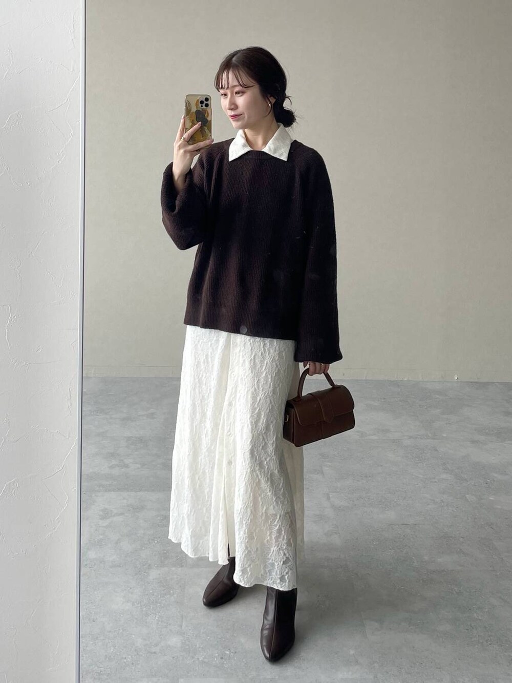 ブラウン系のニット/セーター、ホワイト系のワンピース、ブラウン系のブーツを着用したレディースの秋コーディネートの3枚目の写真