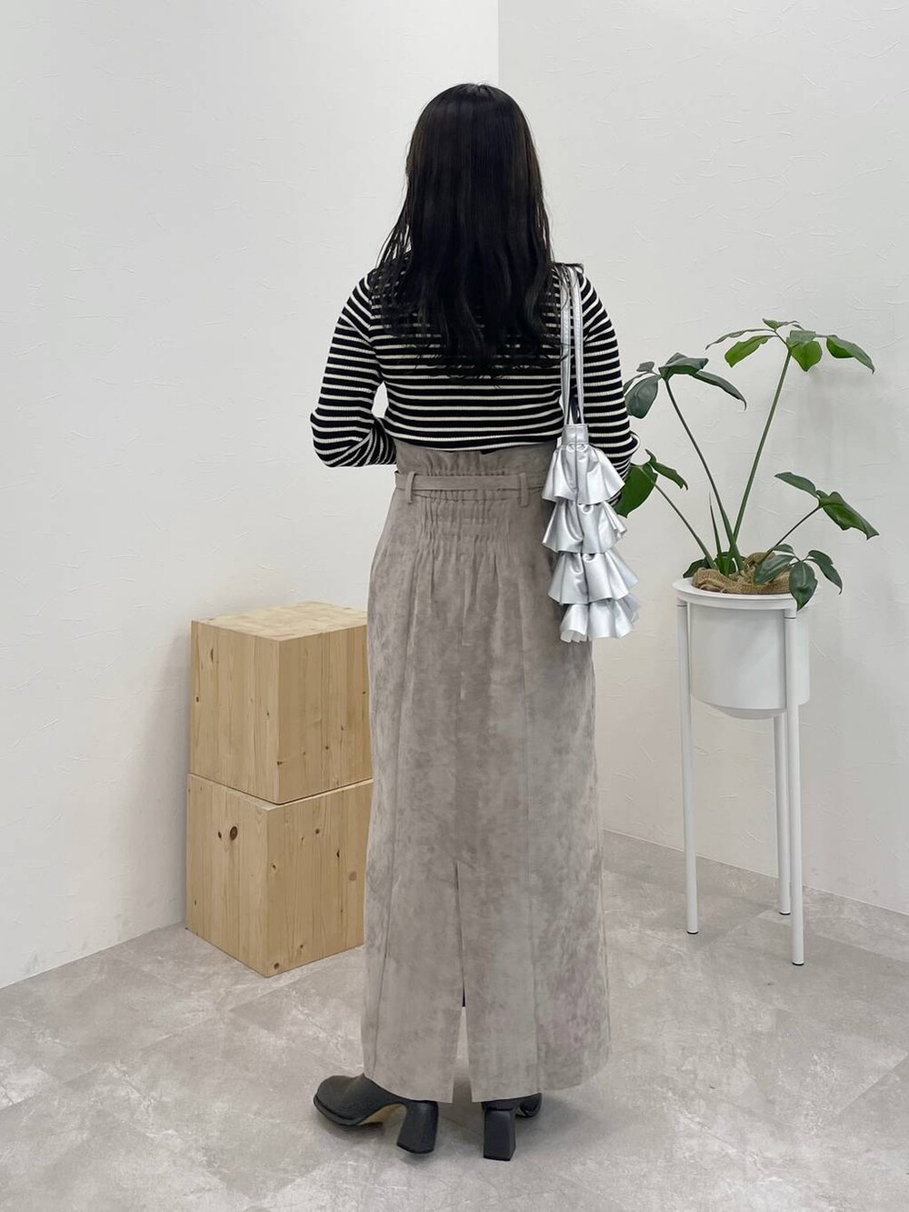 ブラウン系のスカート、グレー系のブーツ、ブラック系のニット/セーターを着用したレディースの冬コーディネートの2枚目の写真