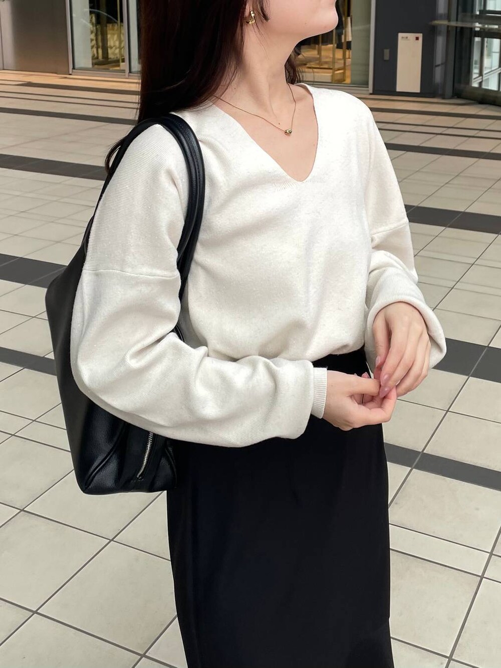 ホワイト系のニット/セーター、ホワイト系のチェスターコート、ブラック系のブーツを着用したレディースの秋コーディネートの7枚目の写真