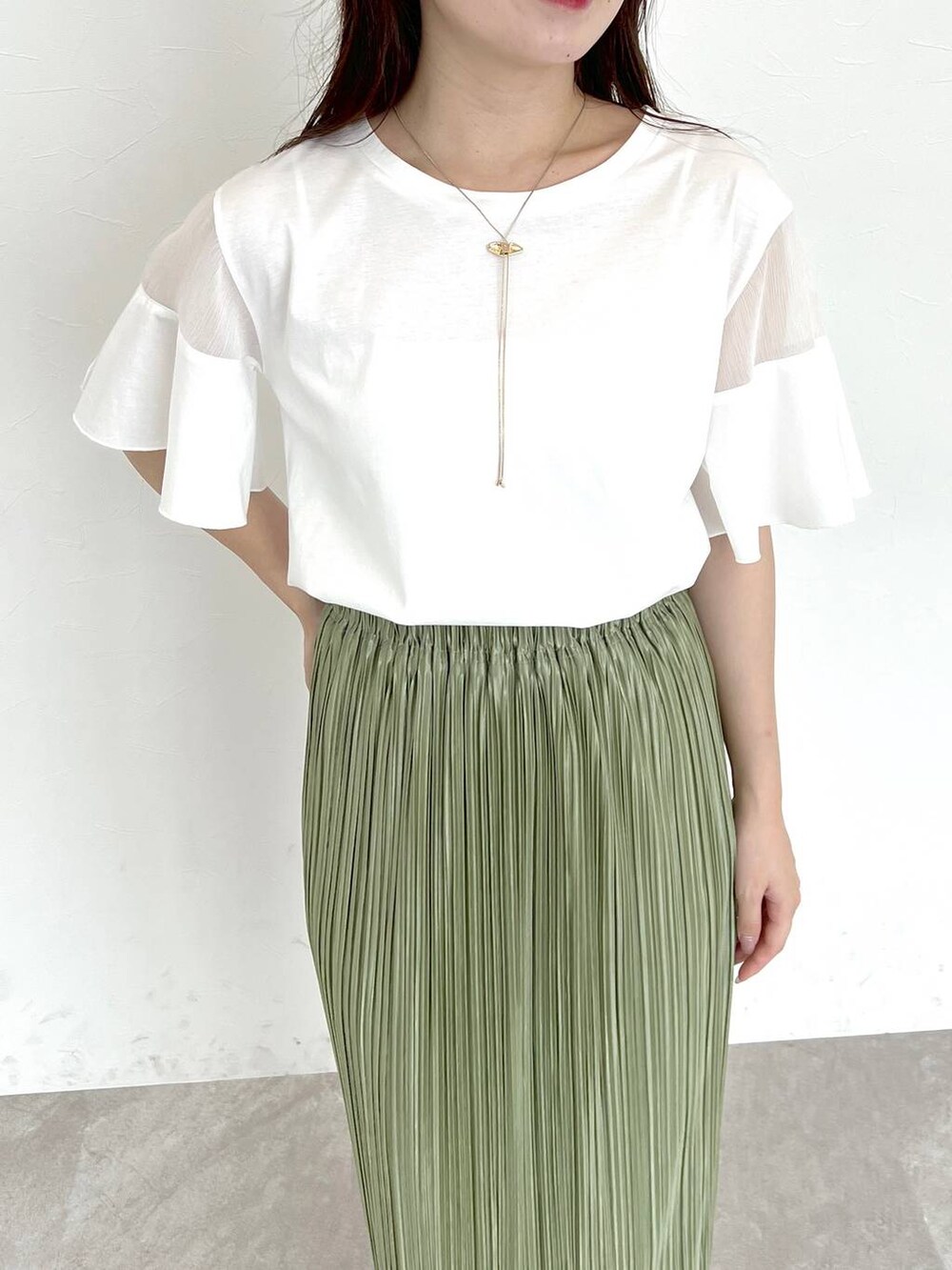 ホワイト系のTシャツ/カットソー、ホワイト系のサンダル、グリーン系のスカートを着用したレディースの夏コーディネートの2枚目の写真