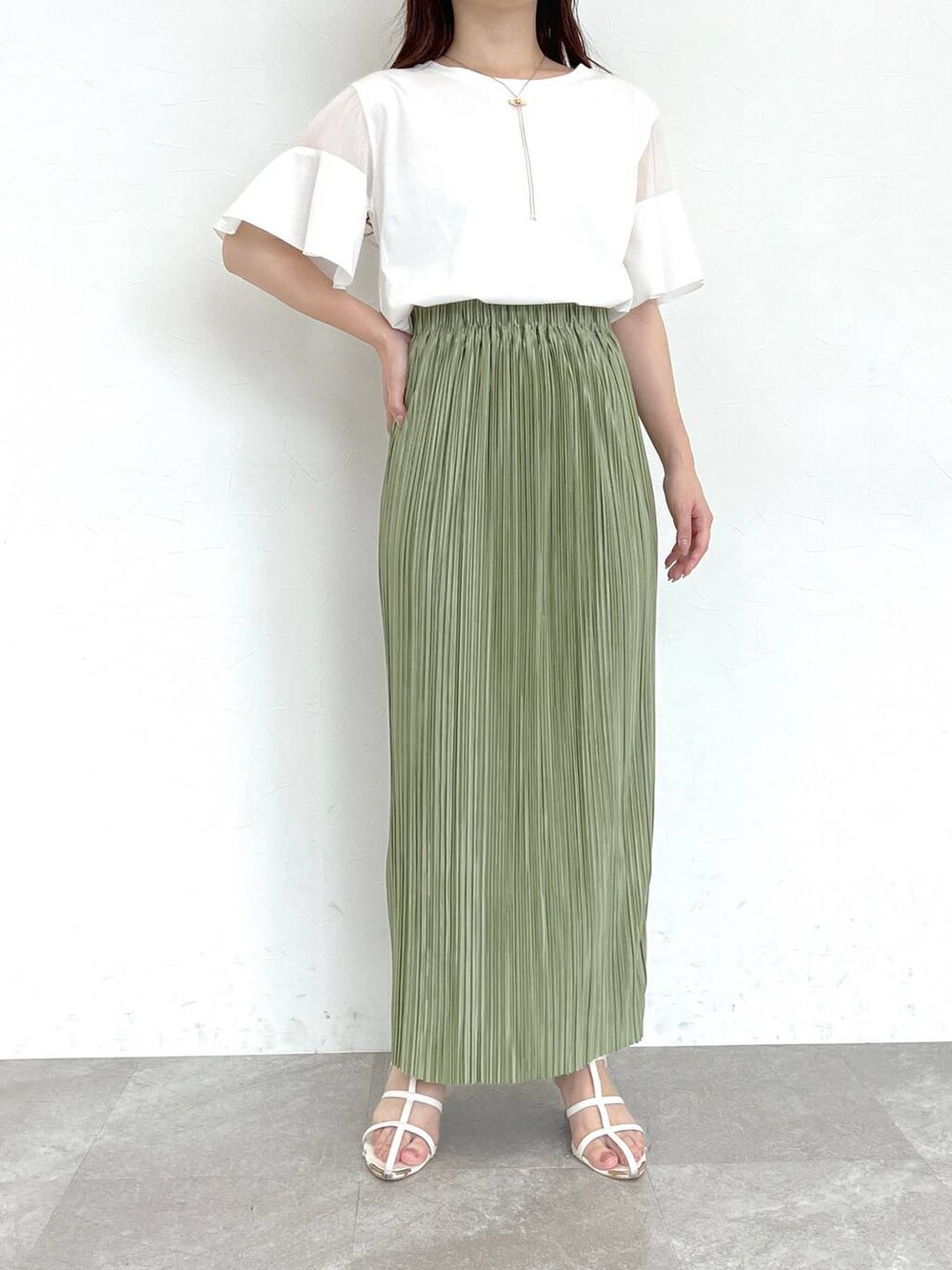 ホワイト系のTシャツ/カットソー、ホワイト系のサンダル、グリーン系のスカートを着用したレディースの夏コーディネートの3枚目の写真