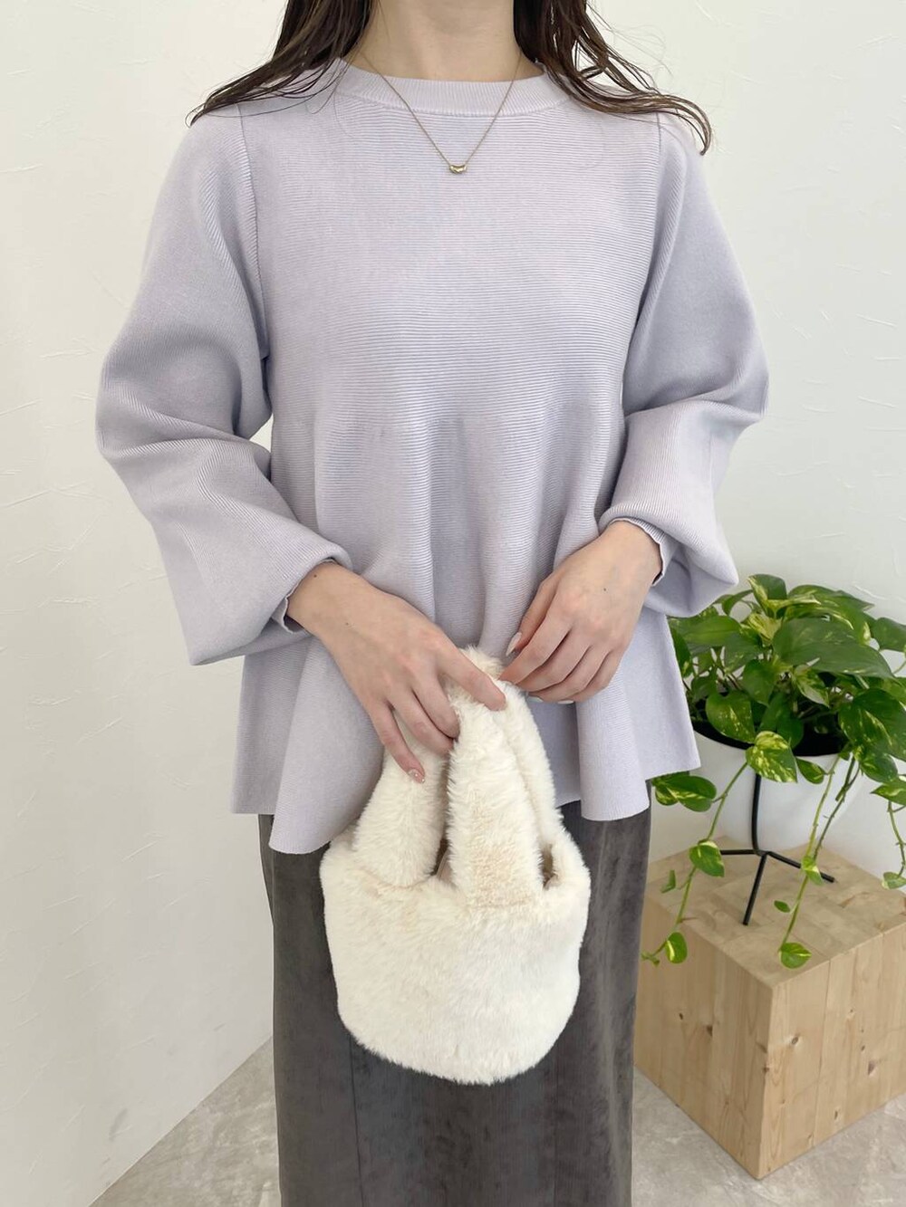 ブラウン系のスカート、ホワイト系のブーツ、ホワイト系のハンドバッグを着用したレディースの冬コーディネートの3枚目の写真